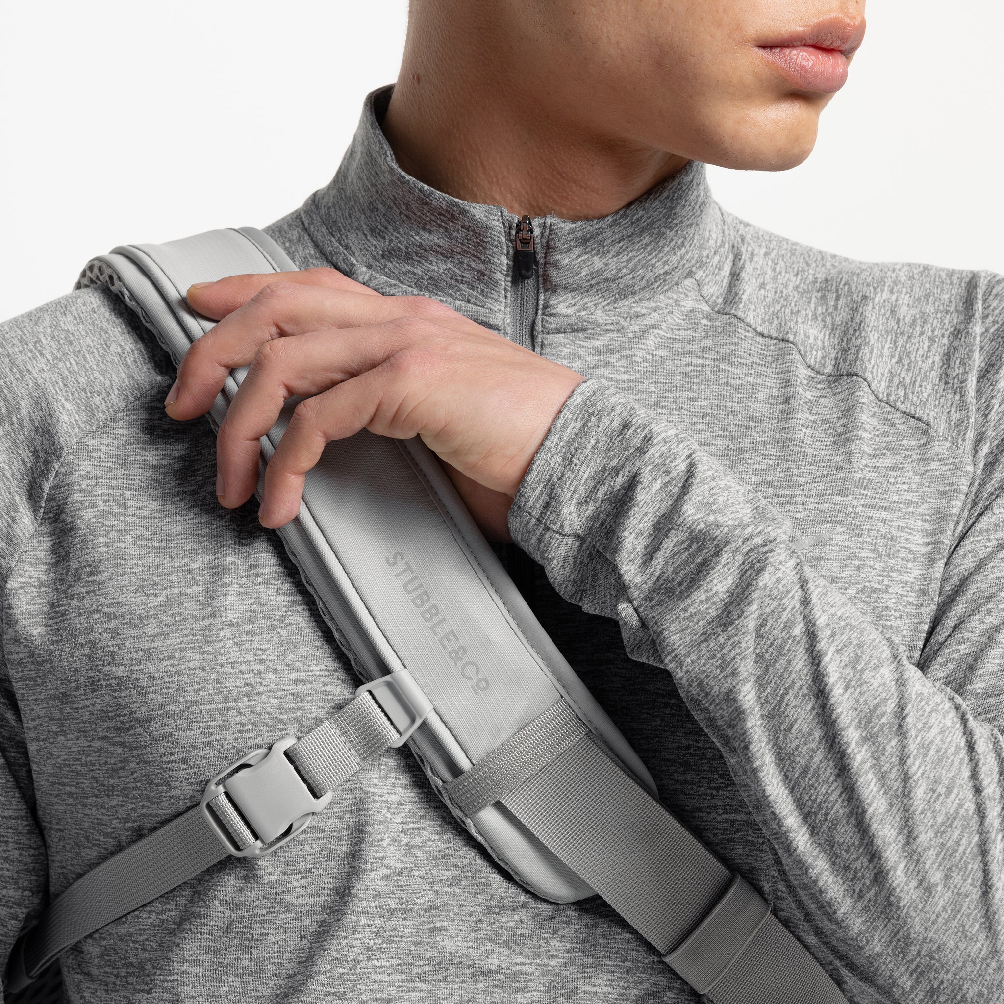 A studio shot of the shoulder strap and reflective logo on the Motion Sling 15L in Ash, Charcoal and Magma