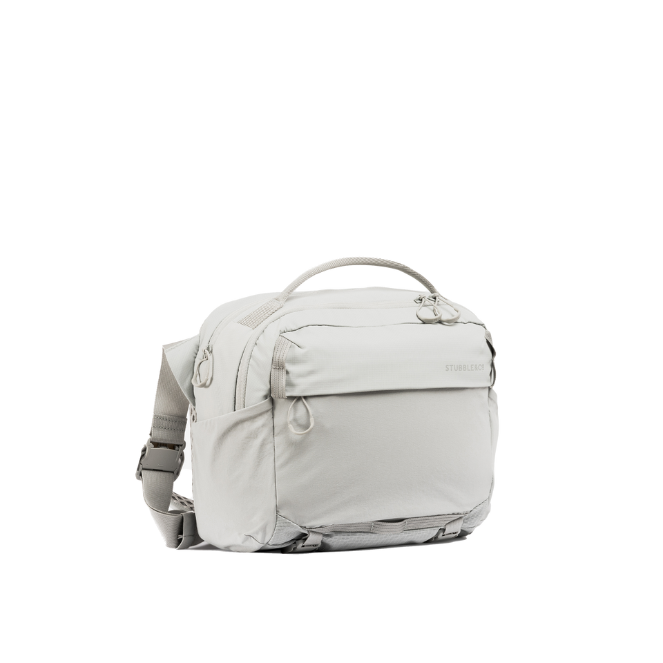 A studio shot of the front and side of an motion sling 15l as cut out transparent PNG-ash