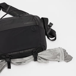A studio shot of the external gear straps and quick release clips on the Charcoal Motion Sling 15L