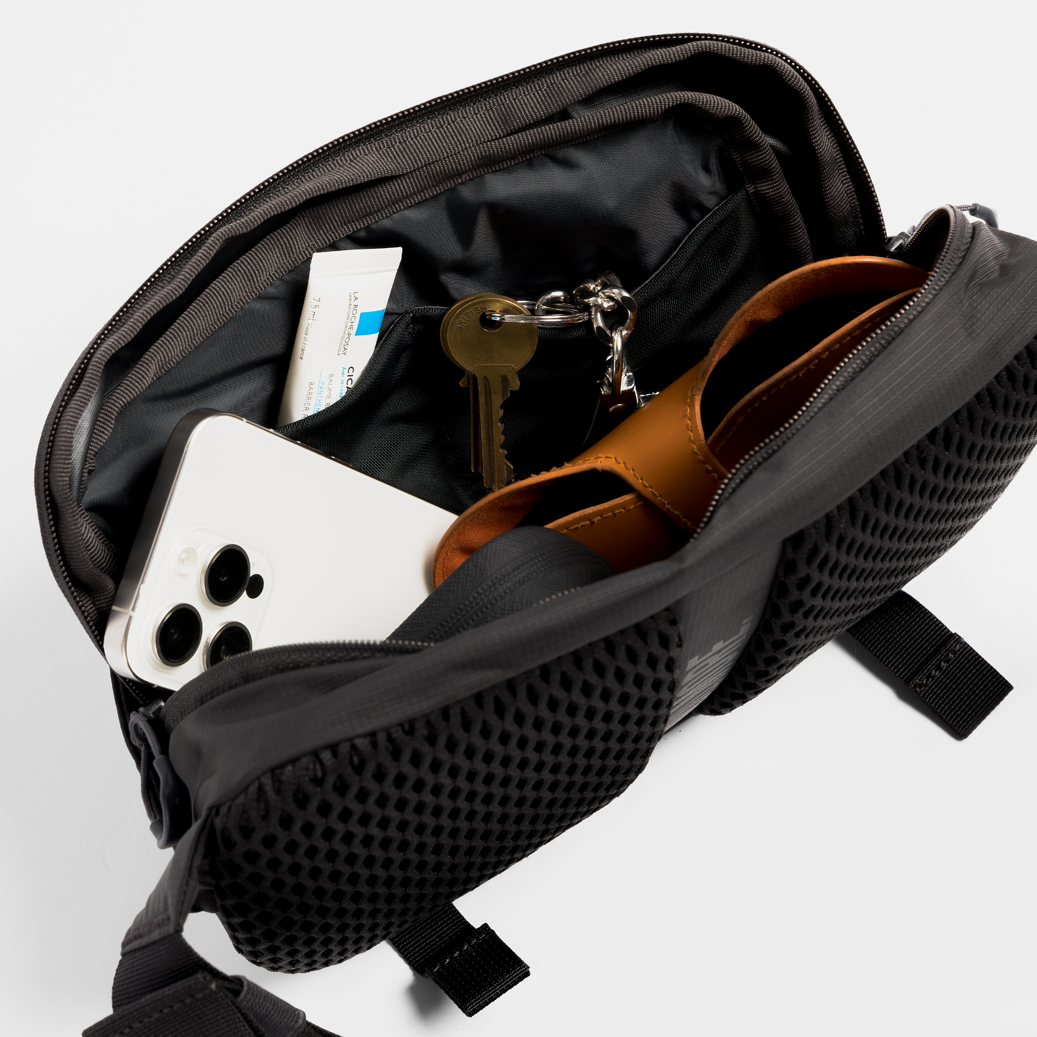 A studio shot of the internal compartments within the motion sling l in Charcoal, Ash and Magma