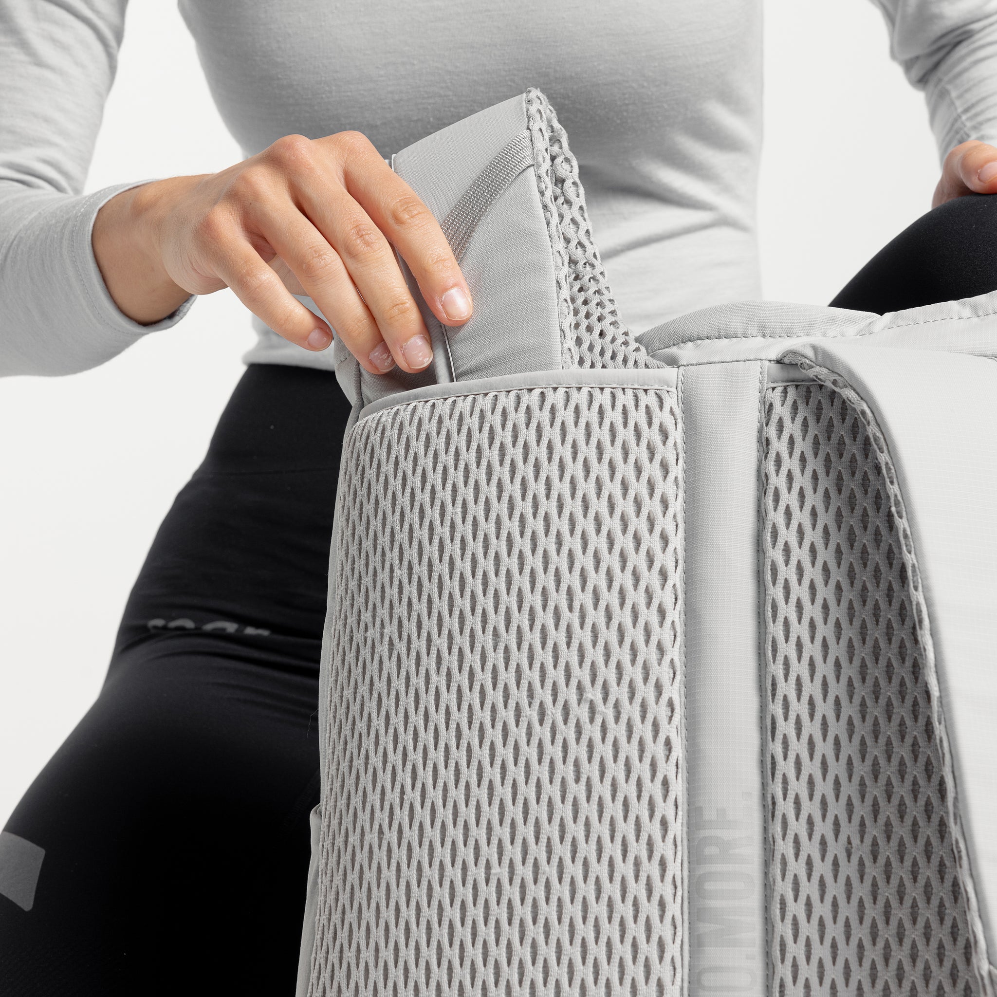 A studio shot showing how the backpack straps on the Motion Tote Pack 18L are tucked away in Ash, Charcoal and Magma