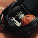 The Kit Bag All Black Backpack open with a basketball inside