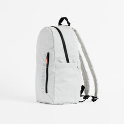 A studio shot of the front and side of the packable backpack in Off-White