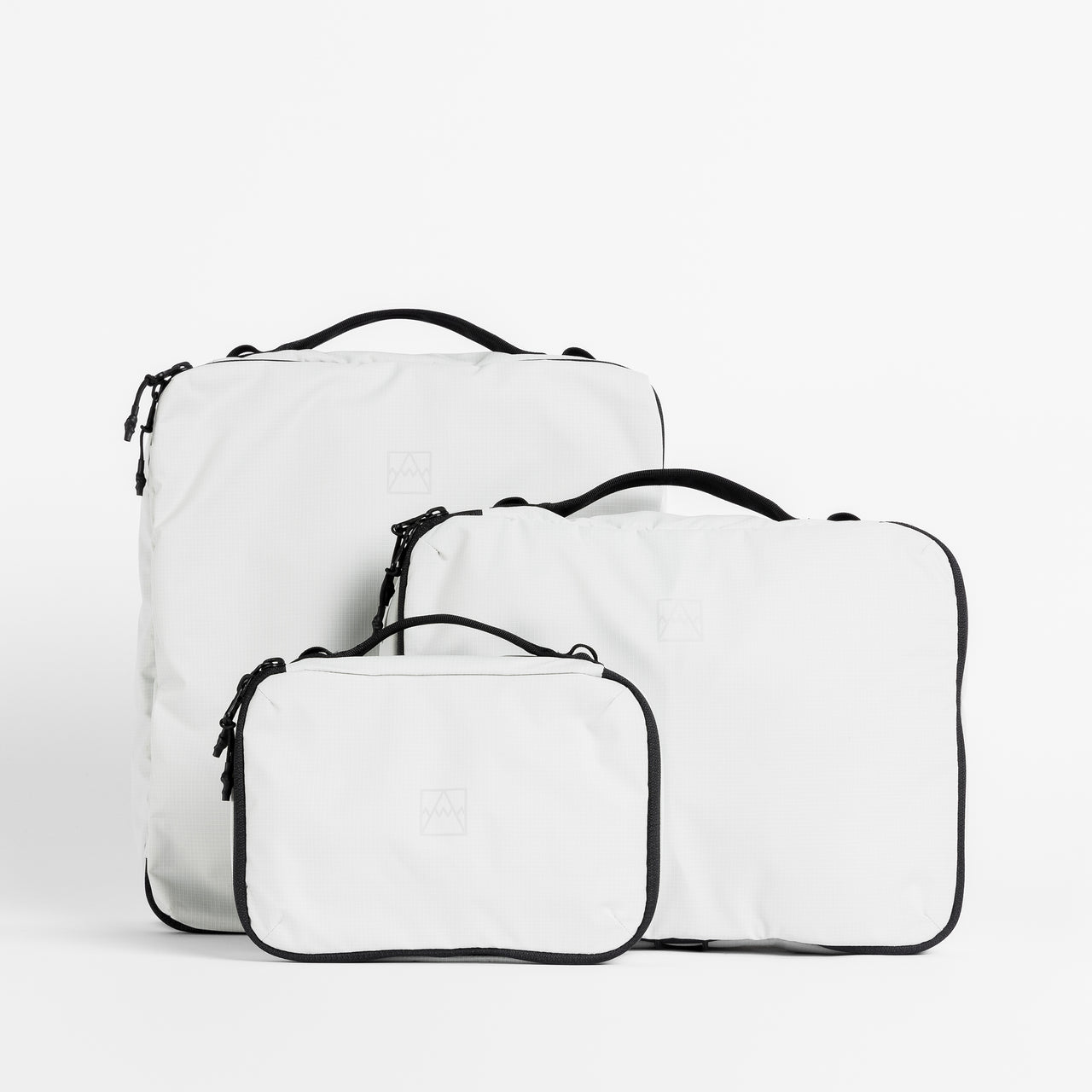 A studio shot of all the packing cube sizes in Off-White