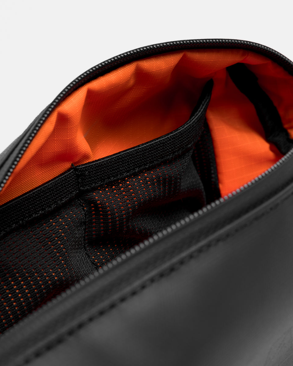 A close up shot of the mesh pockets and orange lining in the pencil case