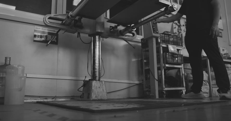 black hardshell suitcase being testing in a factory for durability.