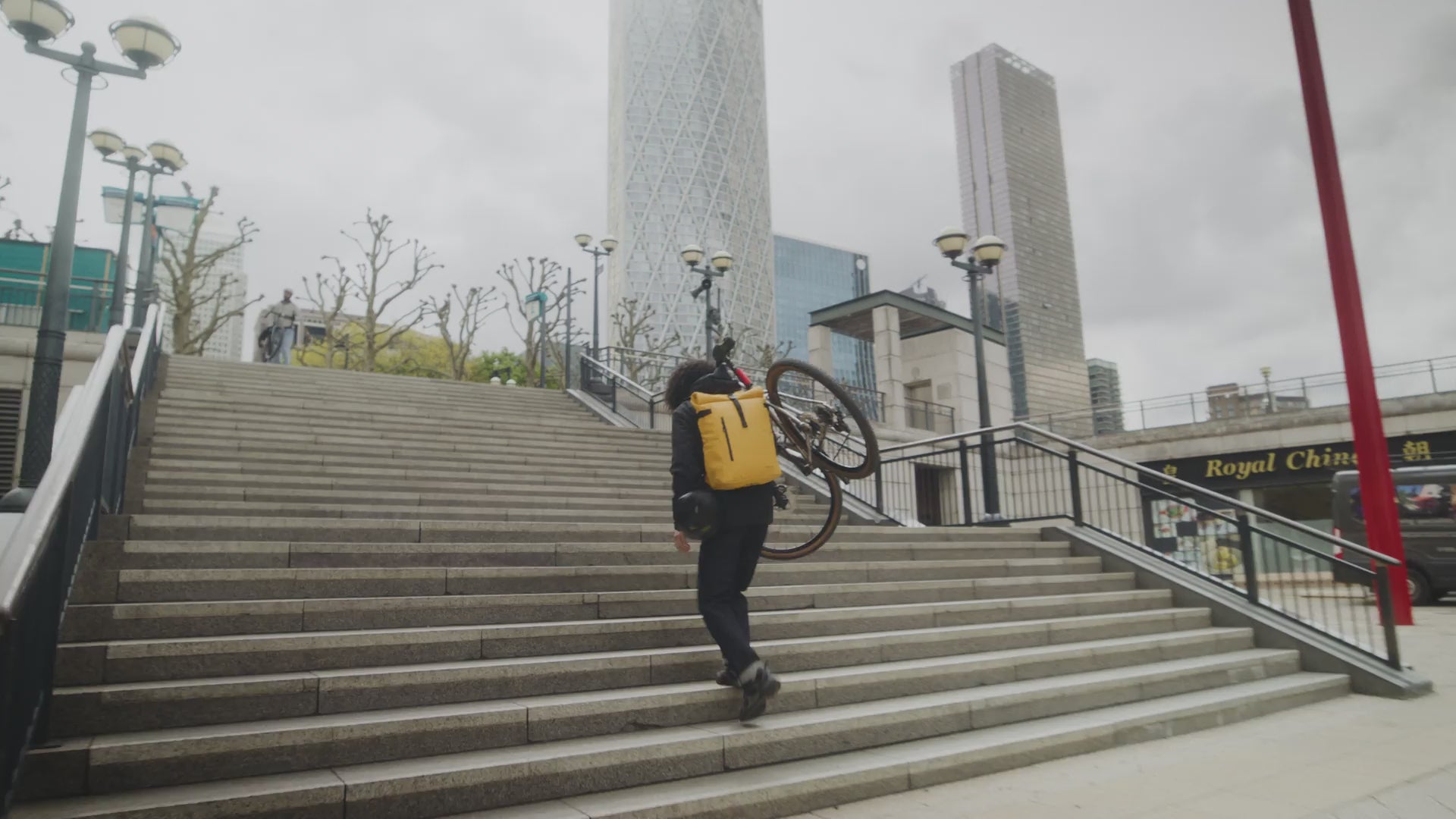 A video of a man on his bike in the city of london with his yellow roll top 30l