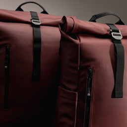 A studio shot of the Roll Top 15L and 20L in Garnet Red side by side