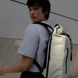 A woman standing side on showing the side of the Roll Top 15L in Soft Mint