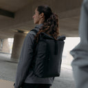 A woman wearing an All Black Roll Top 20L