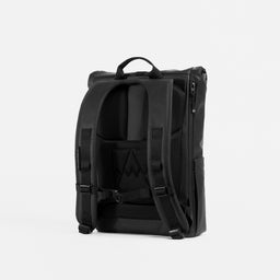 A studio shot of the back panel and adjustable chest straps on the All Black Roll Top 15L