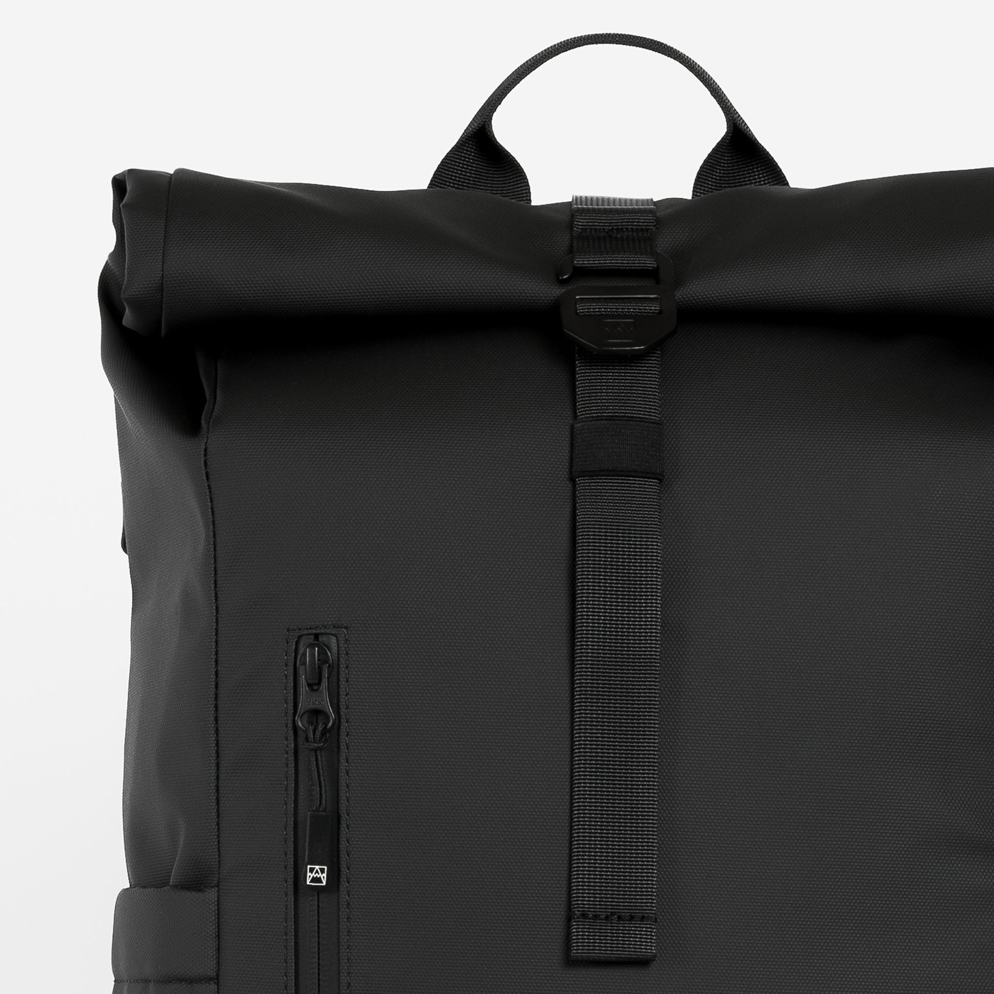 A studio shot of the close up of the roll, g-hook closure and top grab handle on the Roll Top 15L in All Black