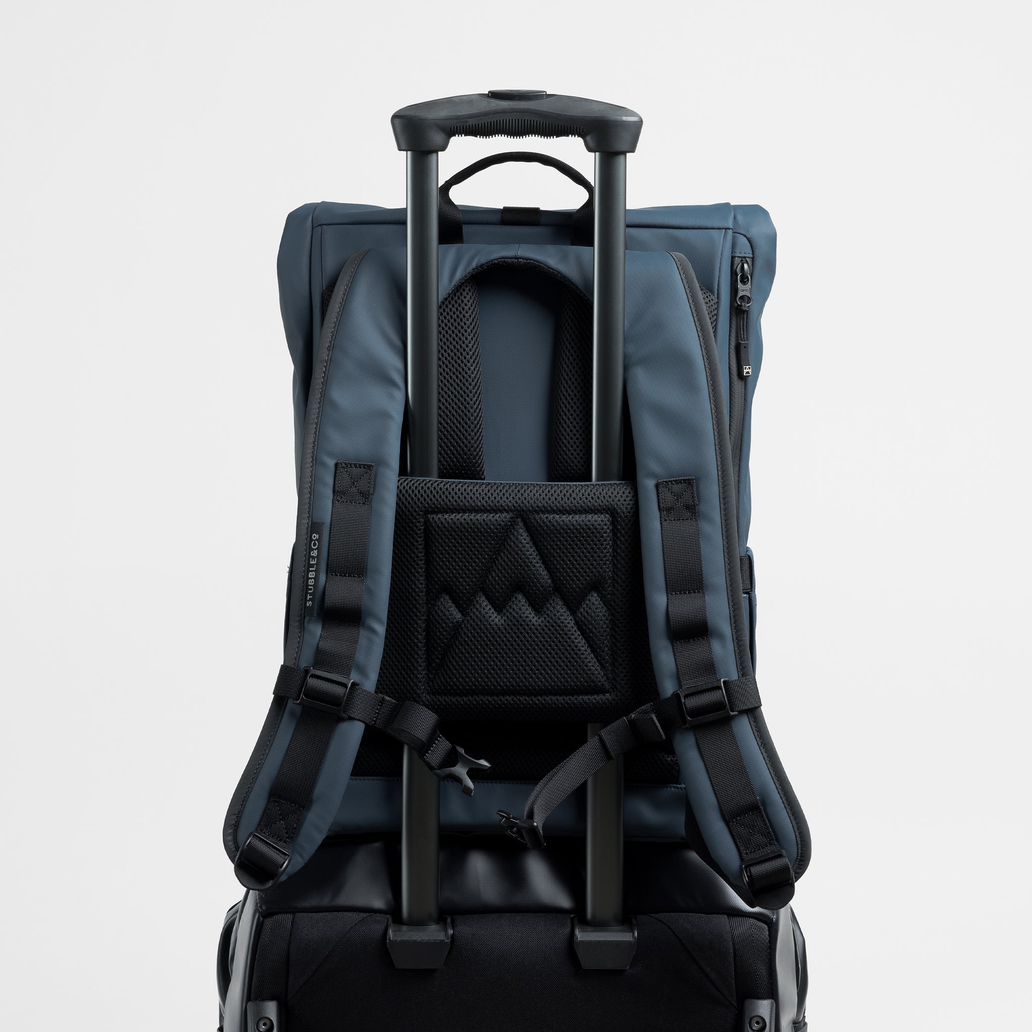 A studio shot of the luggage sleeve on the Roll Top 15L in Tasmin Blue on a suitcase