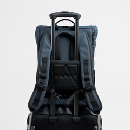 A studio shot of the luggage sleeve on the Roll Top 15L in Tasmin Blue on a suitcase