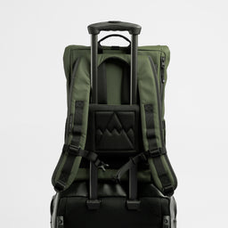 A studio shot of the Roll Top 15L in Urban Green on a suitcase using the luggage sleeve