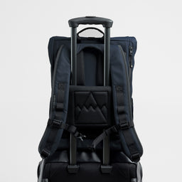A studio shot of a Midnight Blue Roll Top 15L on a suitcase using the luggage sleeve