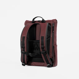 A studio shot of the back panel and adjustable chest straps on the Garnet Red Roll Top 15L