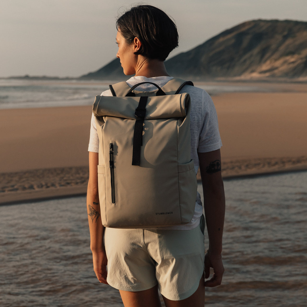 Women wearing The Roll Top 15L in Sand on a beach