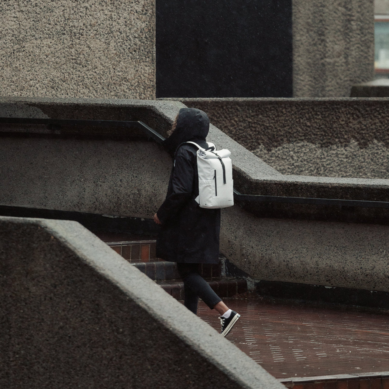 Women wearing The Roll Top 15L in Arctic White walking up steps