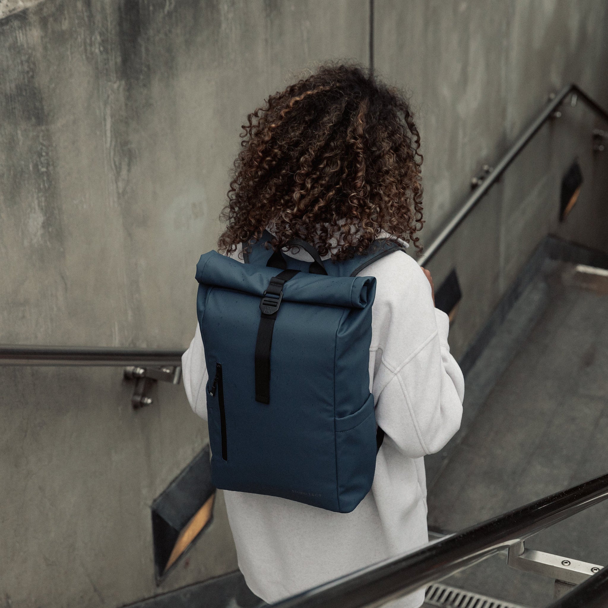 Women wearing the Roll Top 15L in Tasmin Blue walking down steps