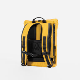 A studio shot of the back panel and adjustable chest straps on the Yellow Roll Top 15L