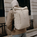 A close up of the Roll Top 20L in Tonal Sand on a man's back