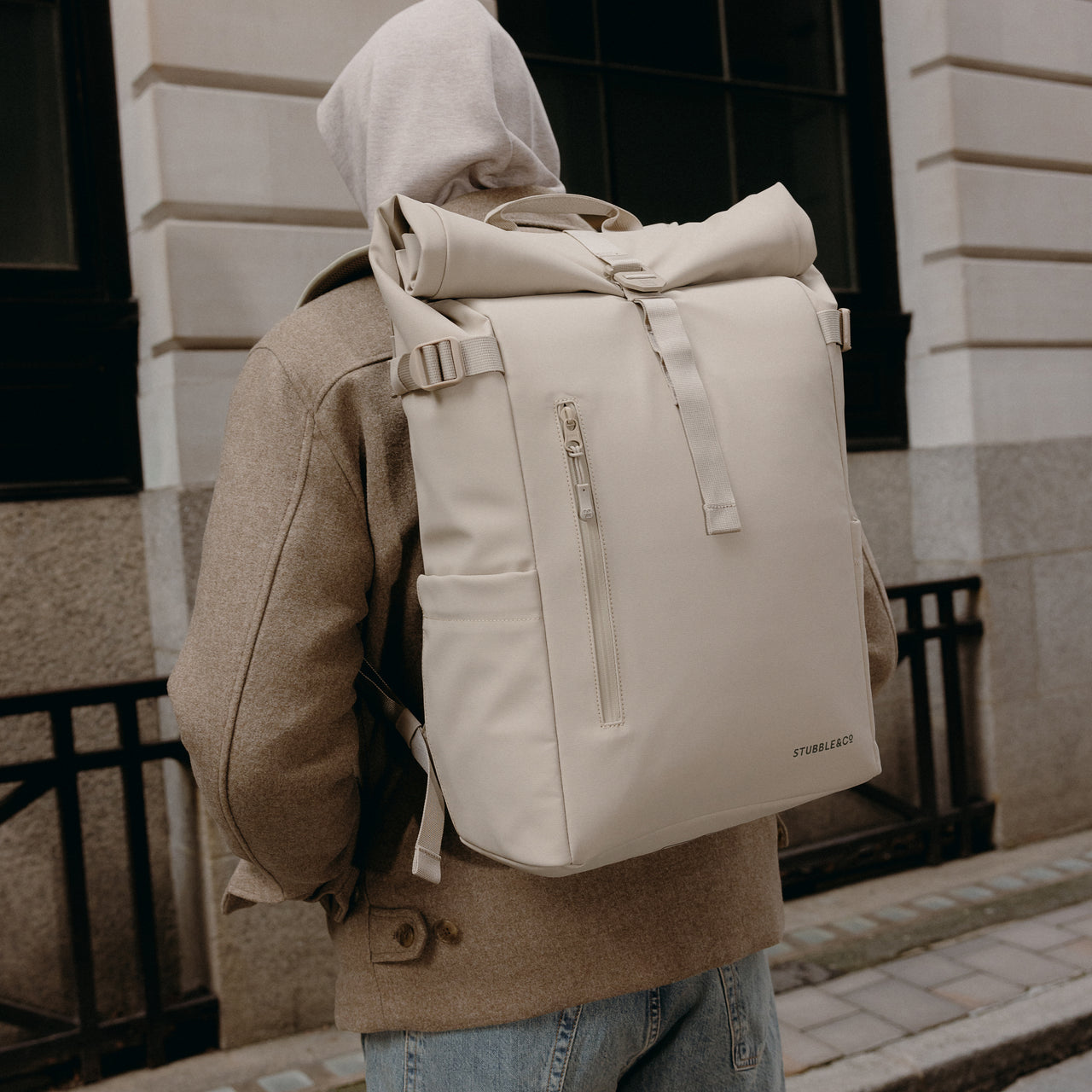 A close up of the Roll Top 20L in Tonal Sand on a man's back