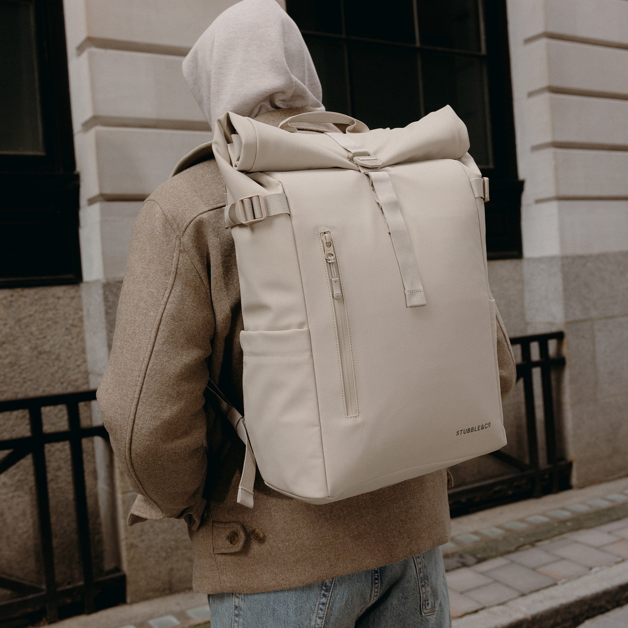 A close up of the Roll Top 20L in Tonal Sand on a man's back