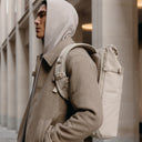 A man wearing a Roll Top 20L backpack in Tonal Sand