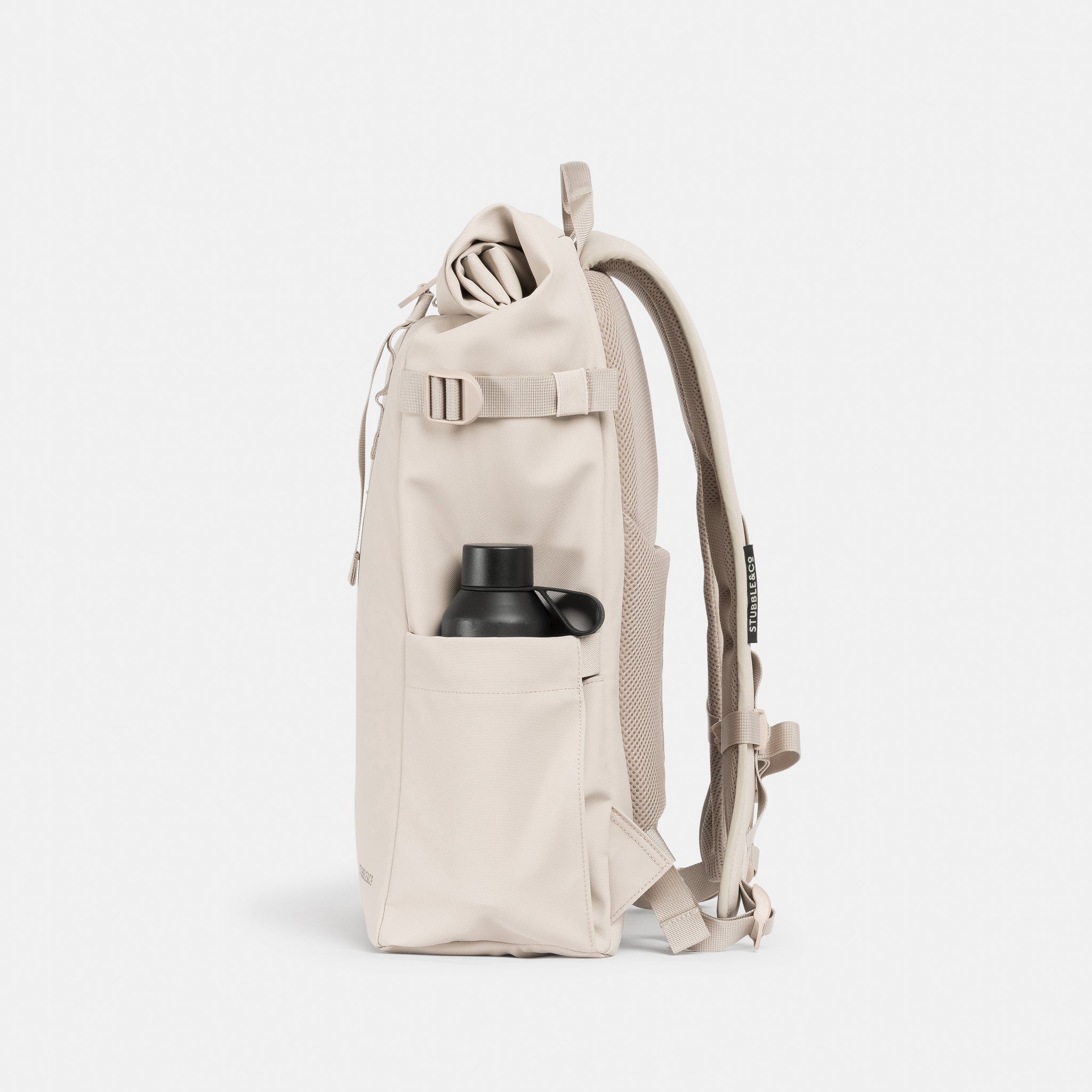 A studio shot of the elasticated bottle pocket on the side of the Roll Top 20L in Tonal Sand