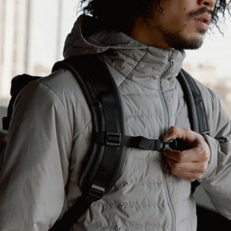 Man fastening the chest strap on The Roll Top 20L in All Black