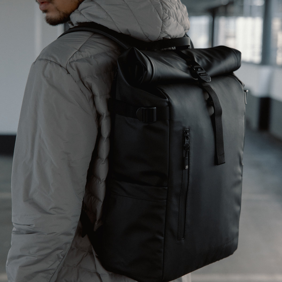 Close-up of The Roll Top 20L in All Black on a man's back