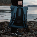 Man carries The Roll Top 20L backpack in Tasmin Blue