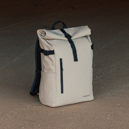 The Roll Top 20L backpack in Sand on a beach