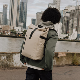 Man wearing The Roll Top 20L backpack in Sand