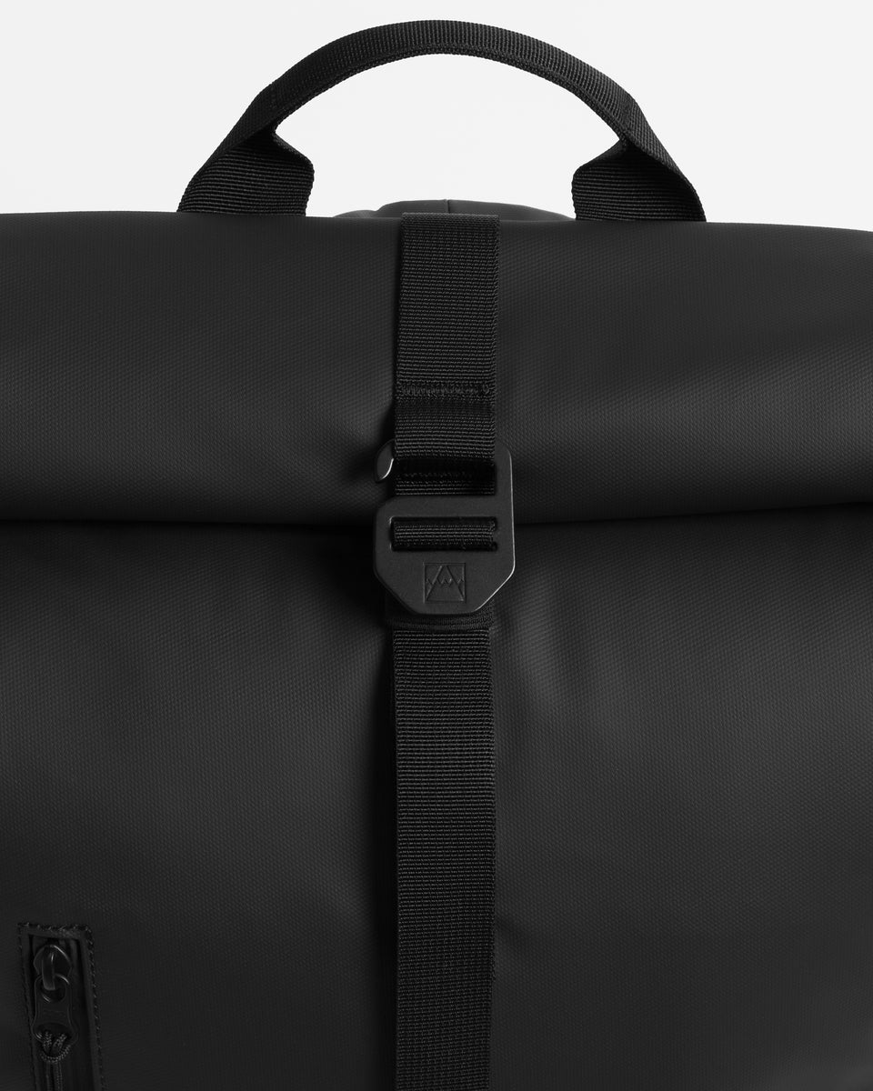Close up of G-hook closure of a black Roll Top backpack