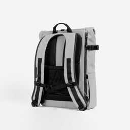A studio shot of the back panel and adjustable chest straps on a Roll Top 20L in Concrete