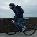 A man cycling a bike wearing a Roll Top 20L in Midnight Blue on his back