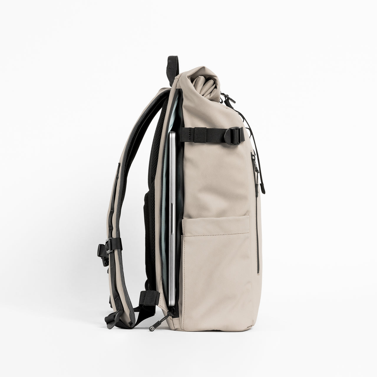 Side view of The Roll Top 20L backpack in Sand with laptop compartment