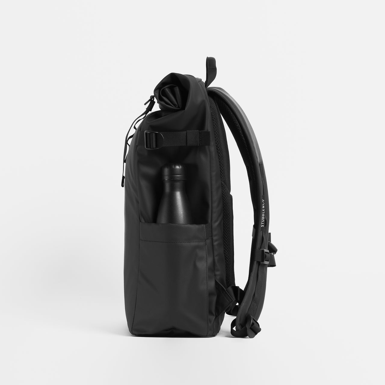 Product shot side view of The Roll Top 20L in All Black with a water bottle in the side pocket.