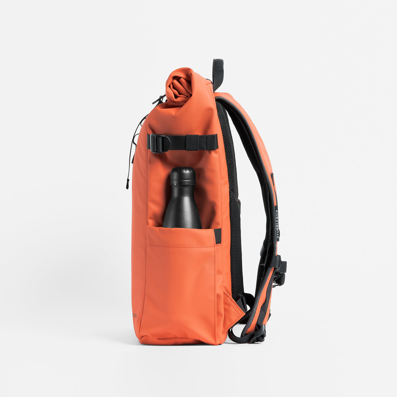 Side view of The Roll Top 20L backpack in Ember Orange