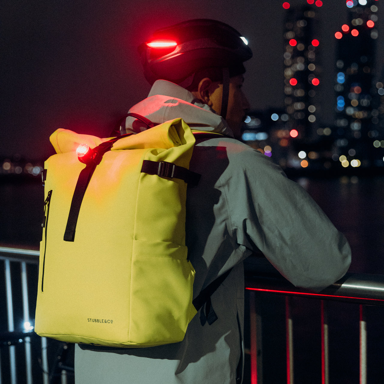 A man wearing a Volt Roll Top 20L on his back leaning on a rail