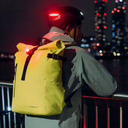 A man wearing a Volt Roll Top 20L on his back leaning on a rail