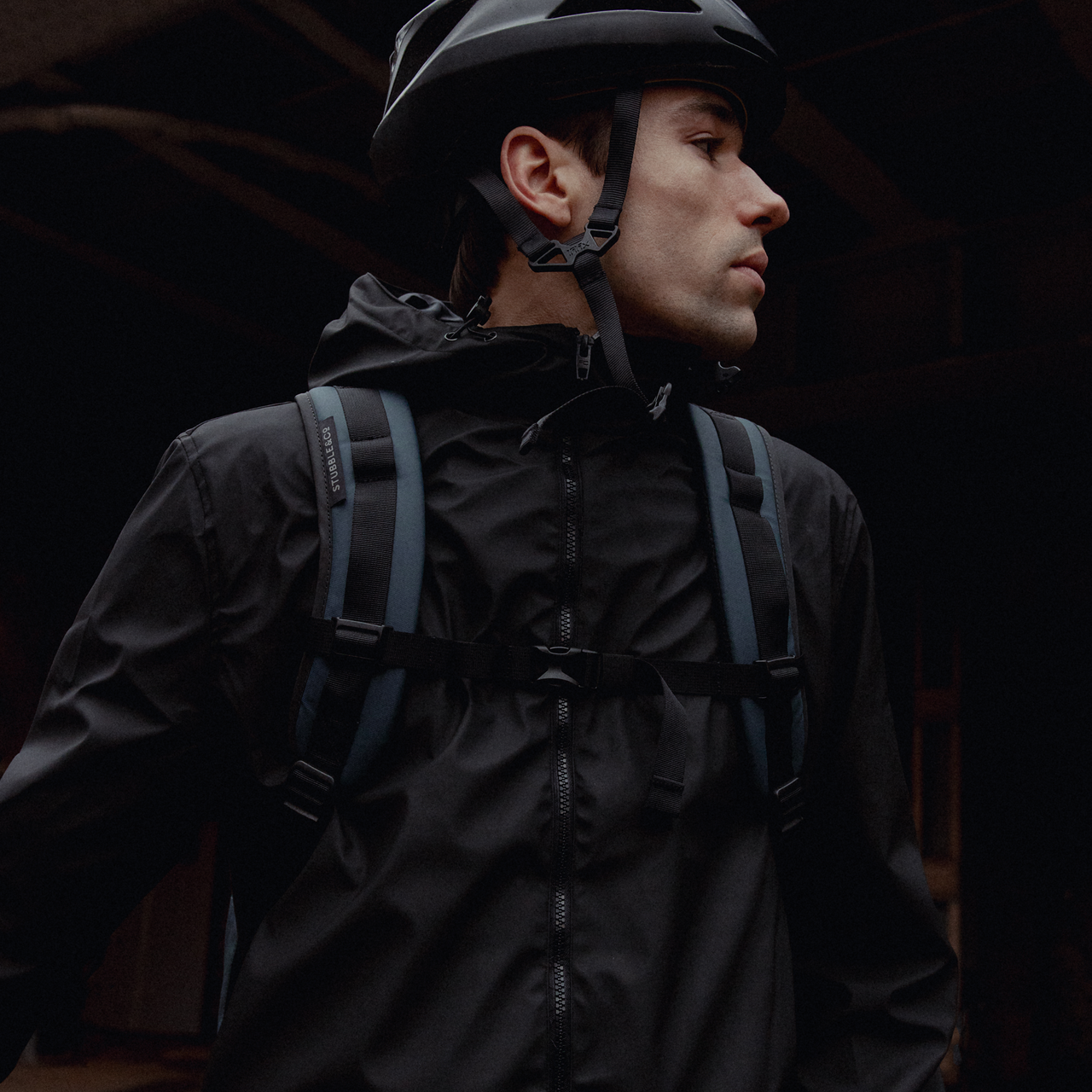 a man wearing a Roll Top 30L in Tasmin Blue on his back with the chest-straps done up