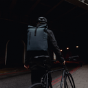 a man standing next to a bike wearing a Roll Top 30L in Tasmin Blue