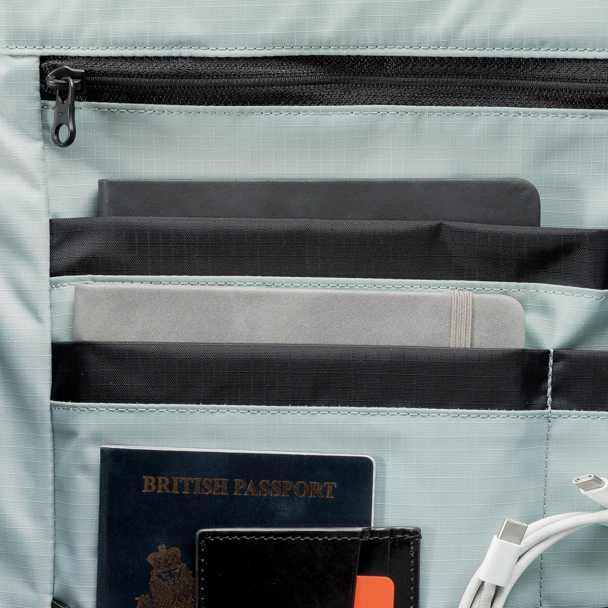 A  studio shot of the Roll Top 30l in Tasmin Blue showing the interior orange lining and organisation