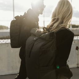 Man and women wearing Roll Top backpack in All Black