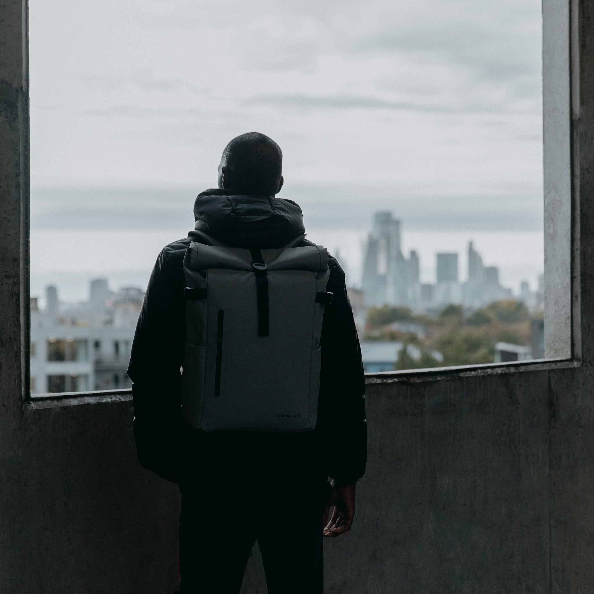 Man looking out over London wearing The Roll Top in Concrete grey.