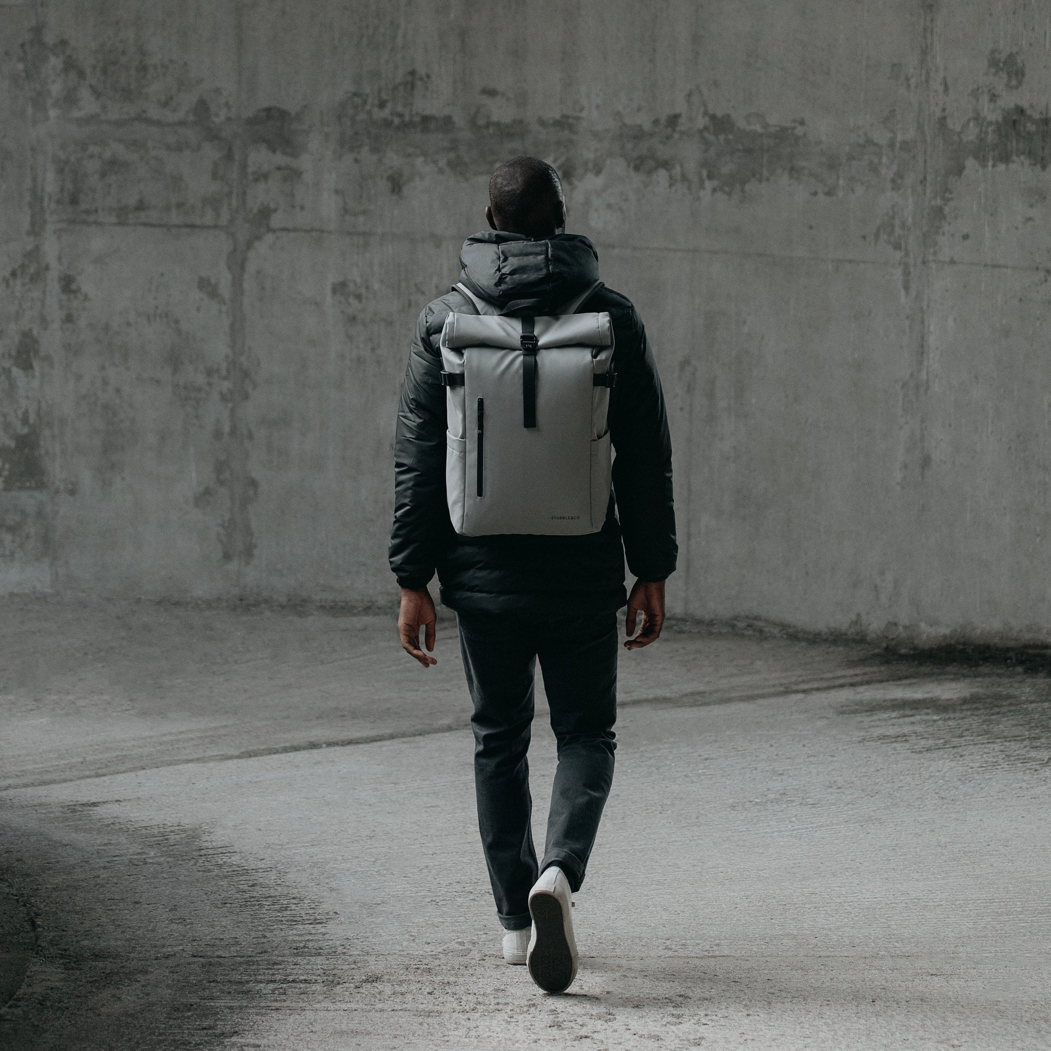 Man walking away from camera wearing The Roll Top in Concrete grey