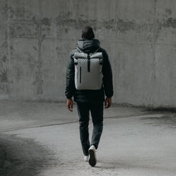 Man walking away from camera wearing The Roll Top in Concrete grey